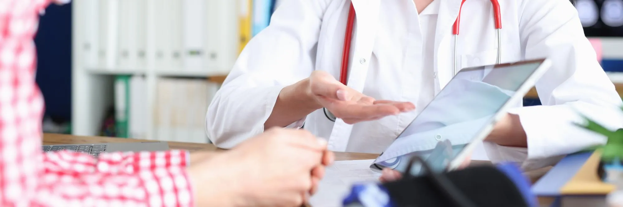 Doctor reviewing a patient’s medical information during a healthcare referral consultation.