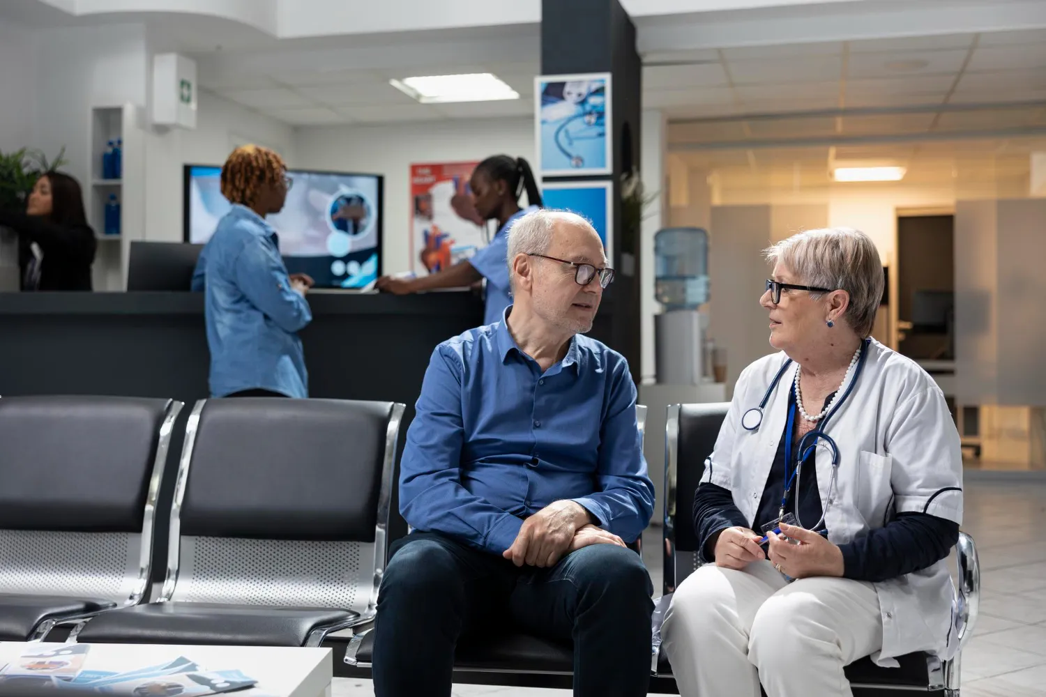 An elderly patient consulting with a healthcare professional in a medical clinic, illustrating how Patient Support Programs help patients navigate healthcare services and access appropriate care.