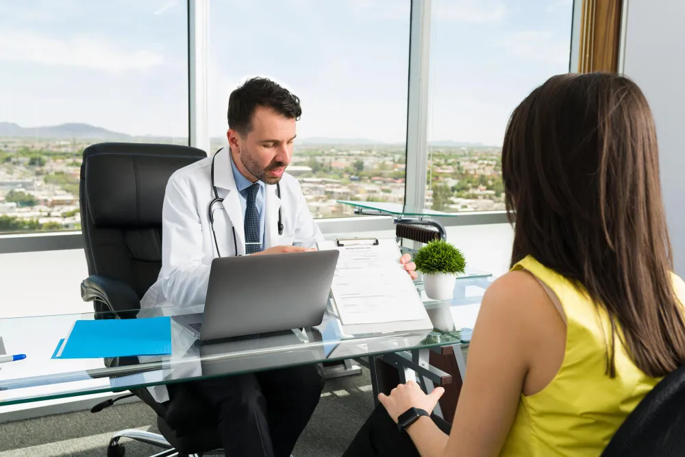 Doctor discussing referral information with a patient, illustrating healthcare referral management and coordinated care.