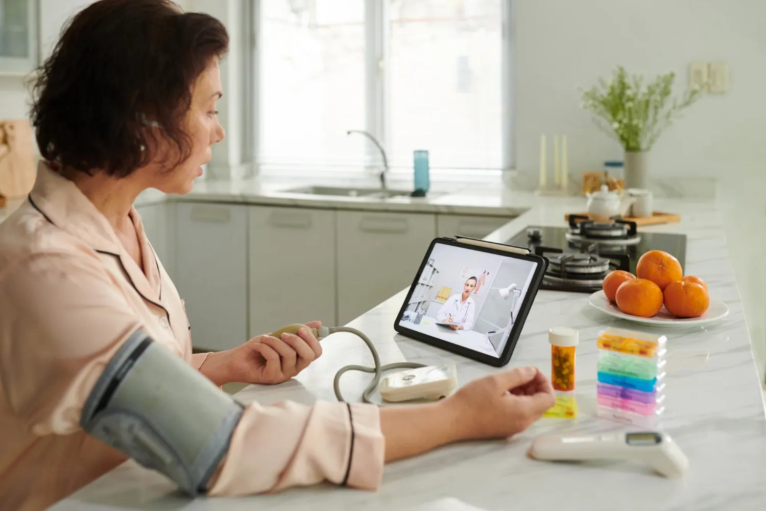 Woman checking blood pressure during remote patient monitoring session for diabetes management and home health monitoring solutions