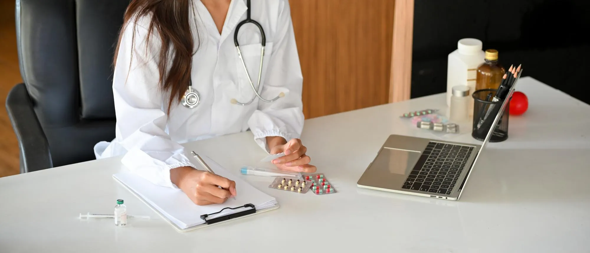Doctor reviewing prescription medication and documenting treatment plan for effective medicine management
