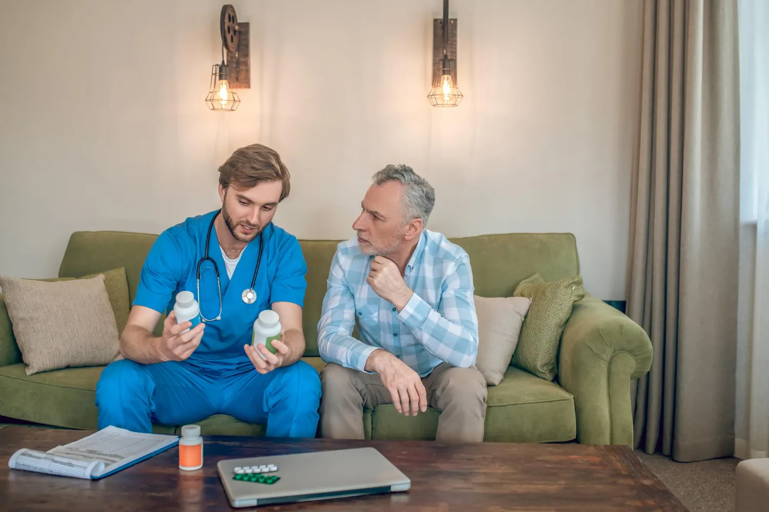 Healthcare provider explaining medications to patient at home highlighting medication reconciliation and home care services