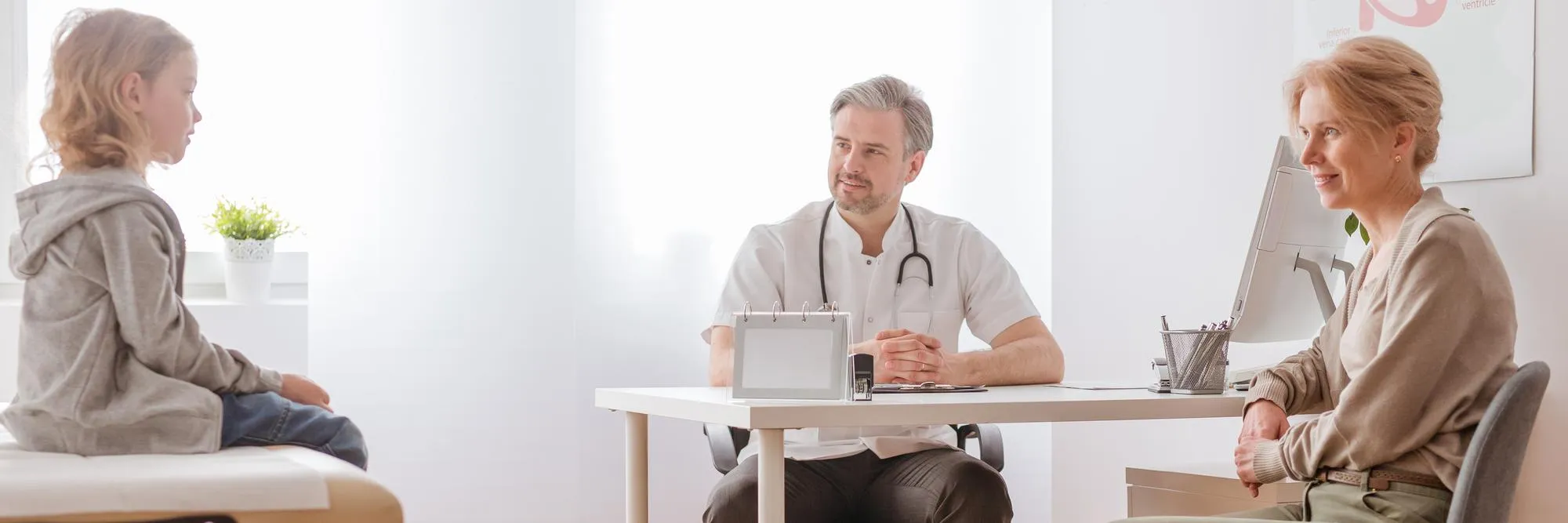 Healthcare provider consulting with patient and caregiver about principal care management for chronic condition treatment and monitoring