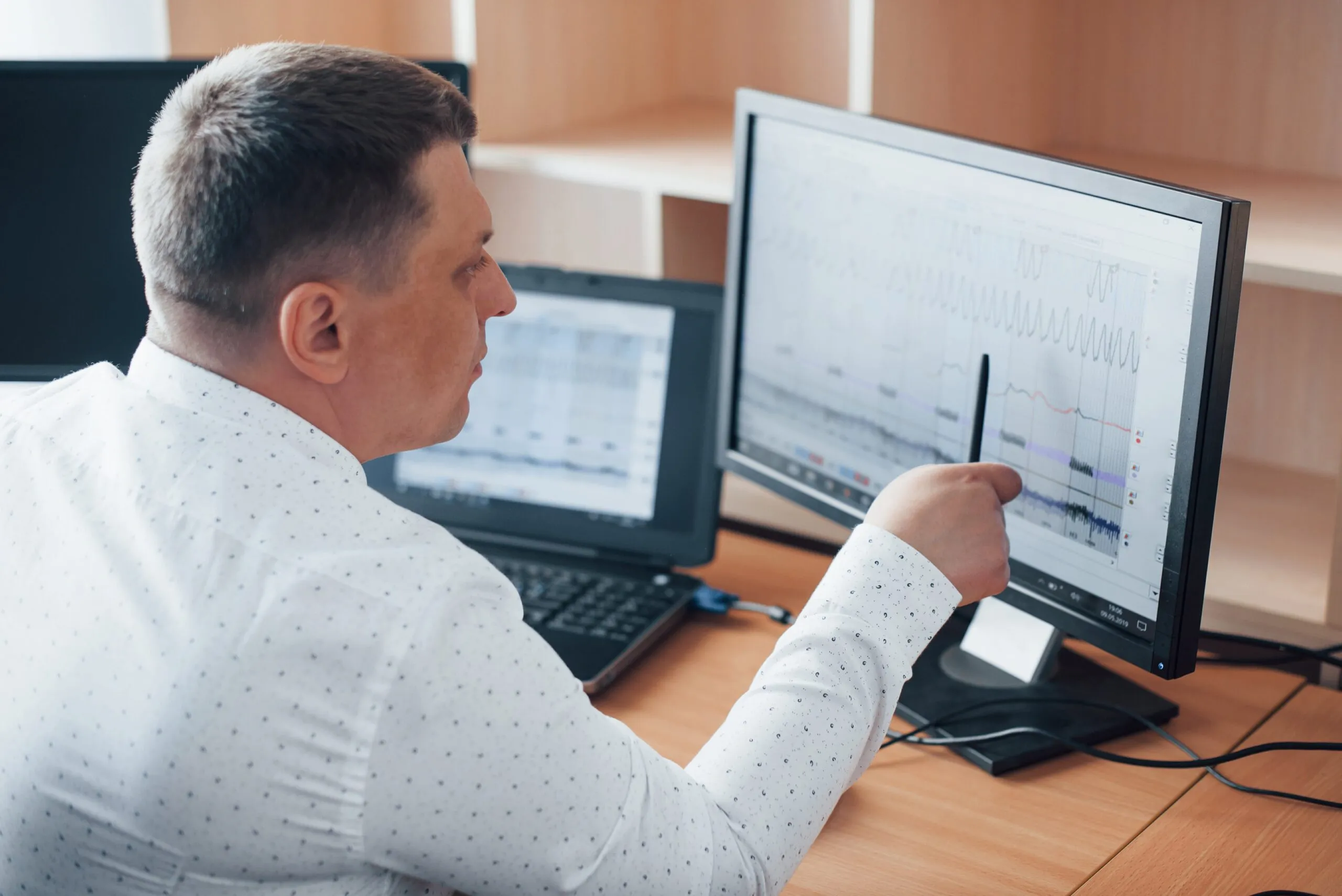 Healthcare professional analyzing real-time patient data on multiple screens, demonstrating advanced remote monitoring software used for continuous tracking and clinical decision-making