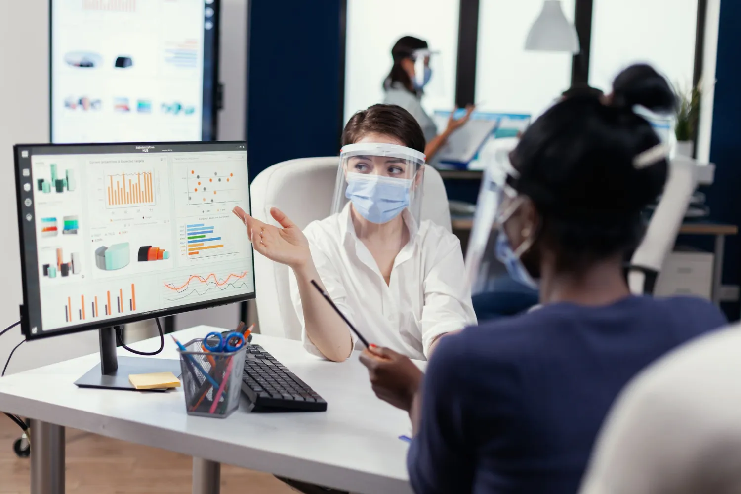 Medical team reviewing analytics dashboards in a clinical setting, highlighting collaborative remote patient monitoring solutions and data-driven care coordination
