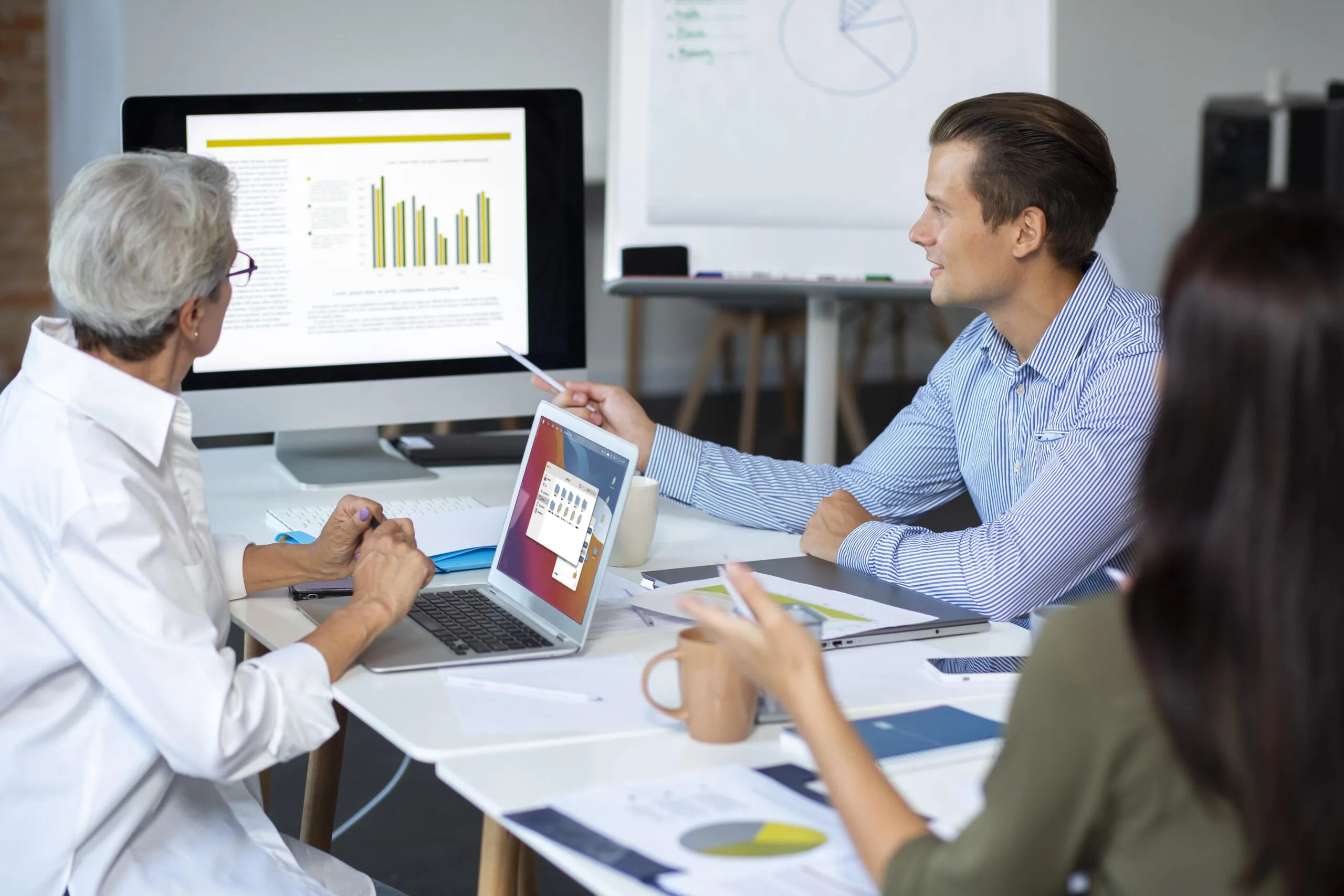 Healthcare professionals reviewing performance charts together, illustrating an efficient referral system that enhances coordination between healthcare providers and improves overall health care services