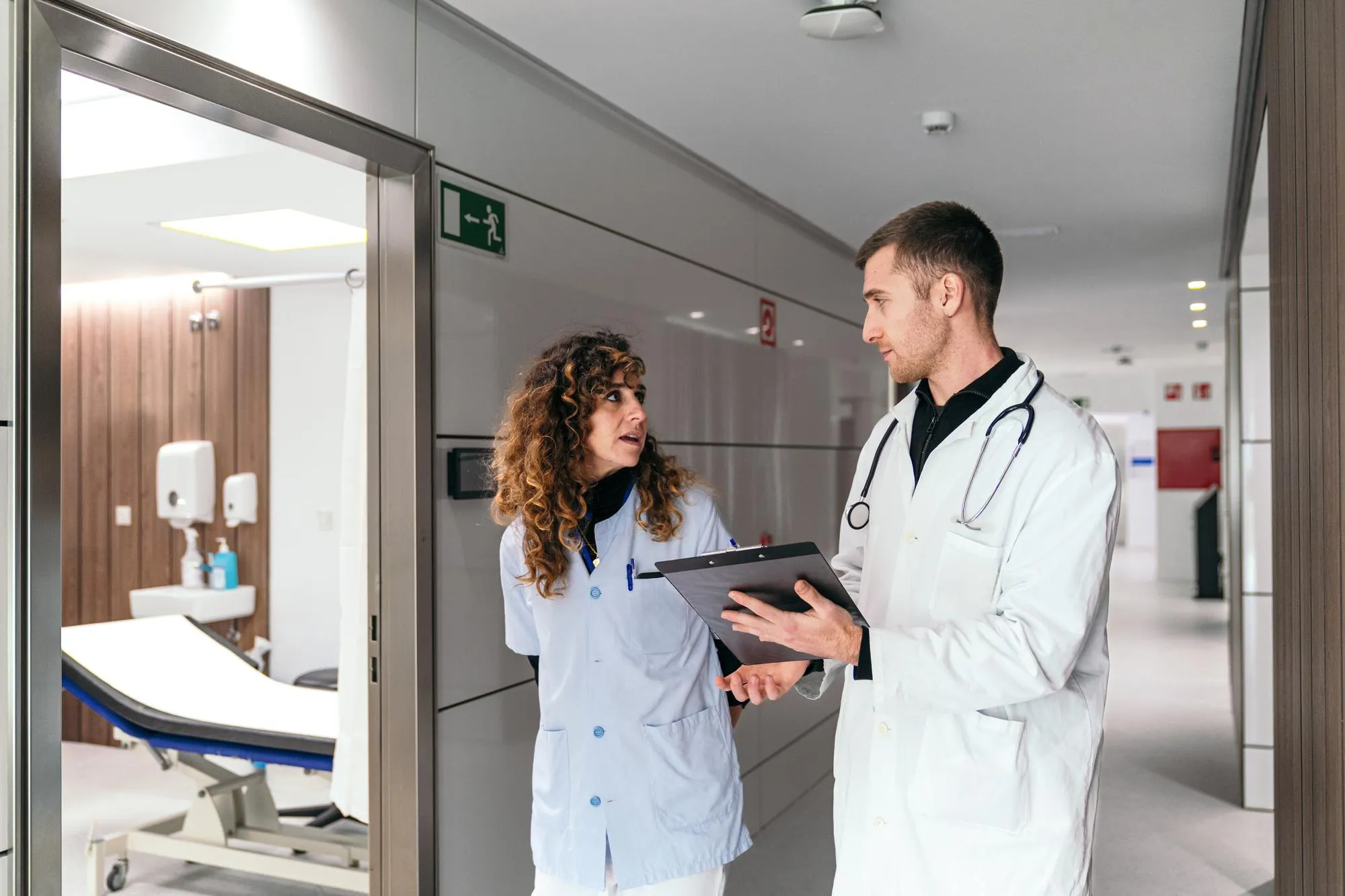 Healthcare professionals discussing patient information in a clinical setting, highlighting coordinated health management information and collaborative care planning