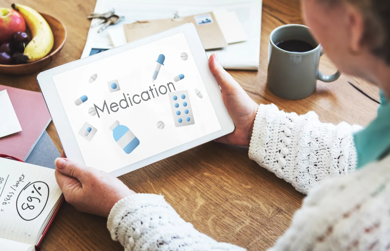 Individual using a tablet displaying medication information, highlighting digital medication adherence counseling and support tools