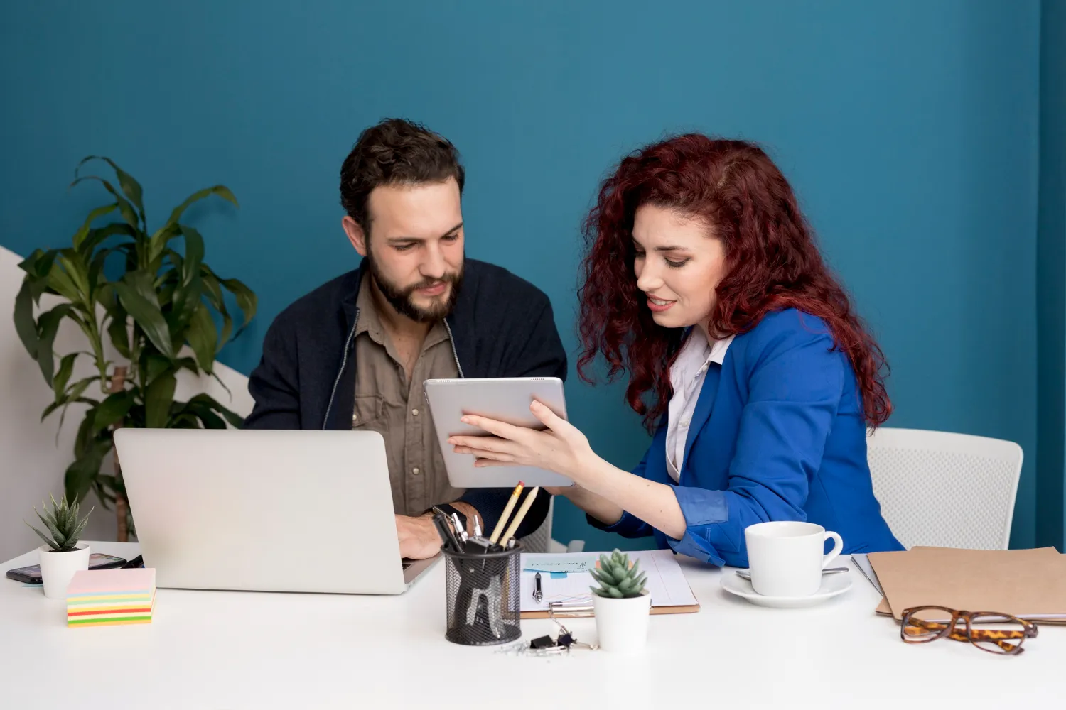 Healthcare professionals collaborating over a tablet and laptop, representing efficient patient referral management solutions and streamlined referral workflow management in modern practices