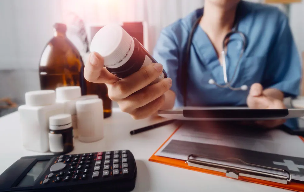 Healthcare professional reviewing a prescription bottle with a patient, showcasing medication counseling support and professional guidance