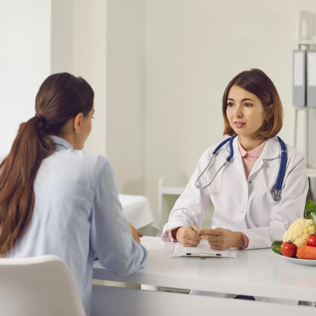 Female doctor consulting with a patient at a clinic — Central Health Solutions chronic care management and remote patient support services