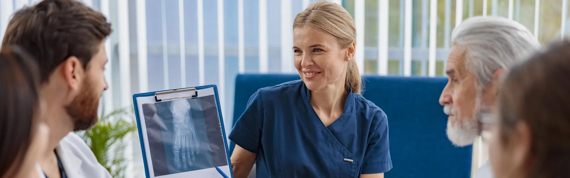 Doctor explaining an X-ray to patients during a consultation, representing Principal Care Management services and personalized chronic condition care management for improved patient outcomes