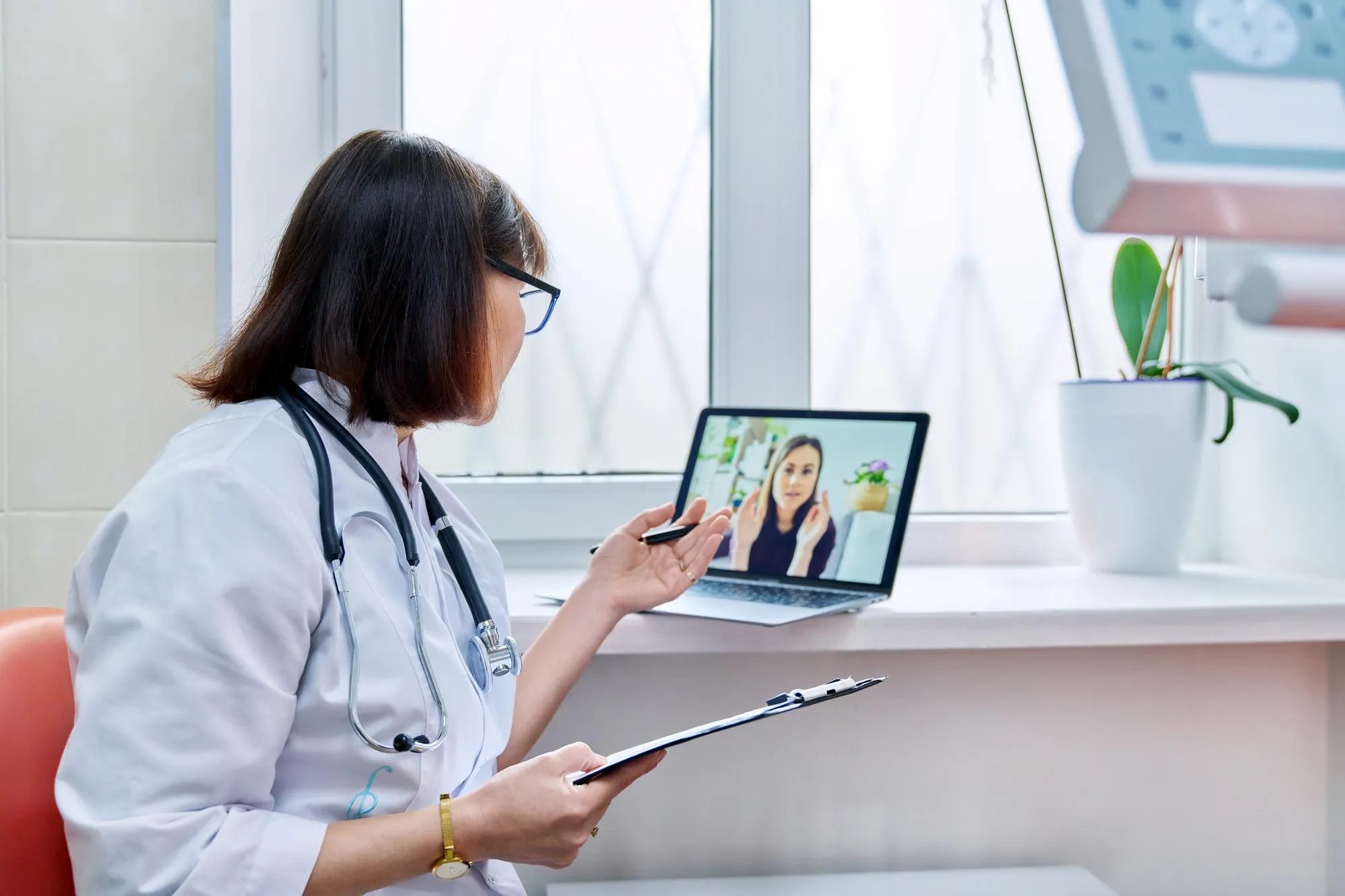Healthcare provider conducting a remote patient monitoring consultation with a patient through a secure telehealth platform while reviewing health information remotely.