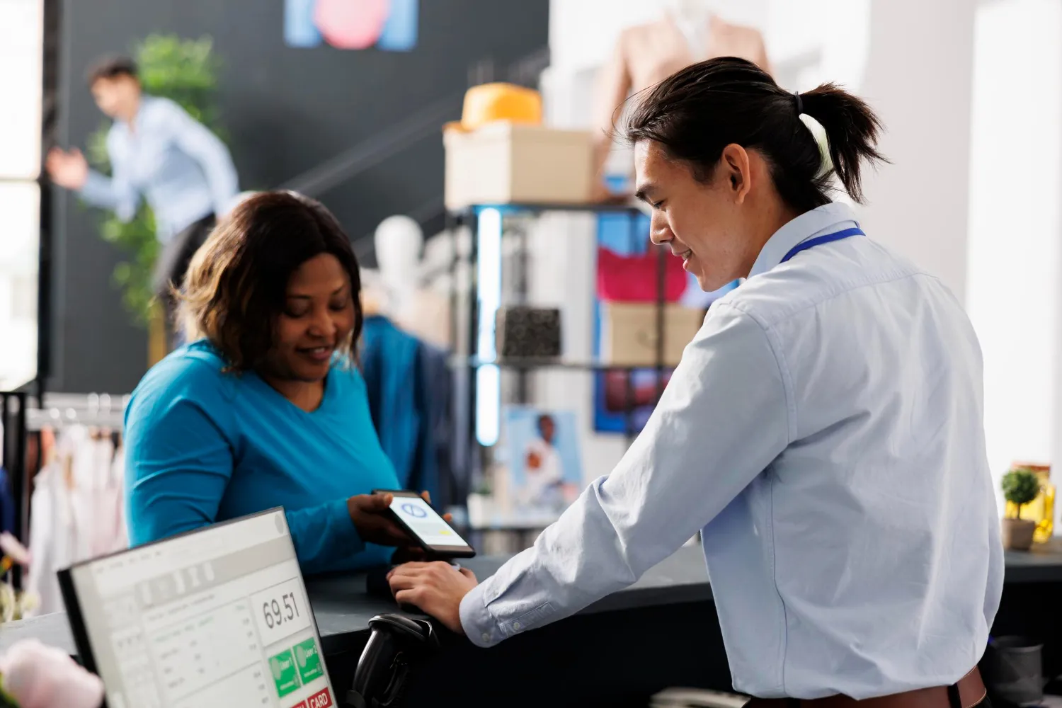 Patient completing a digital payment at a healthcare service desk, supporting Revenue Cycle Management through efficient billing, payment collection, and improved patient financial experience.