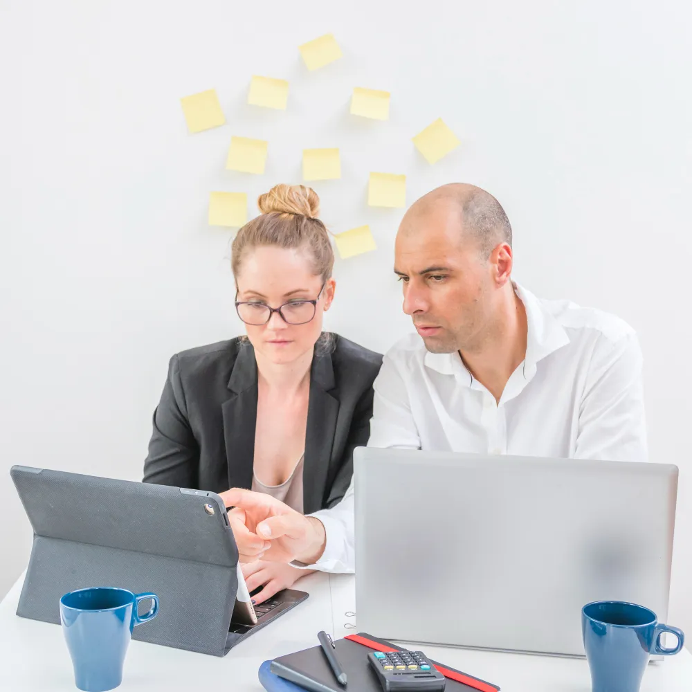 Healthcare professionals reviewing referral management services on a tablet and laptop, supporting efficient patient referral management solutions and referral management consulting.