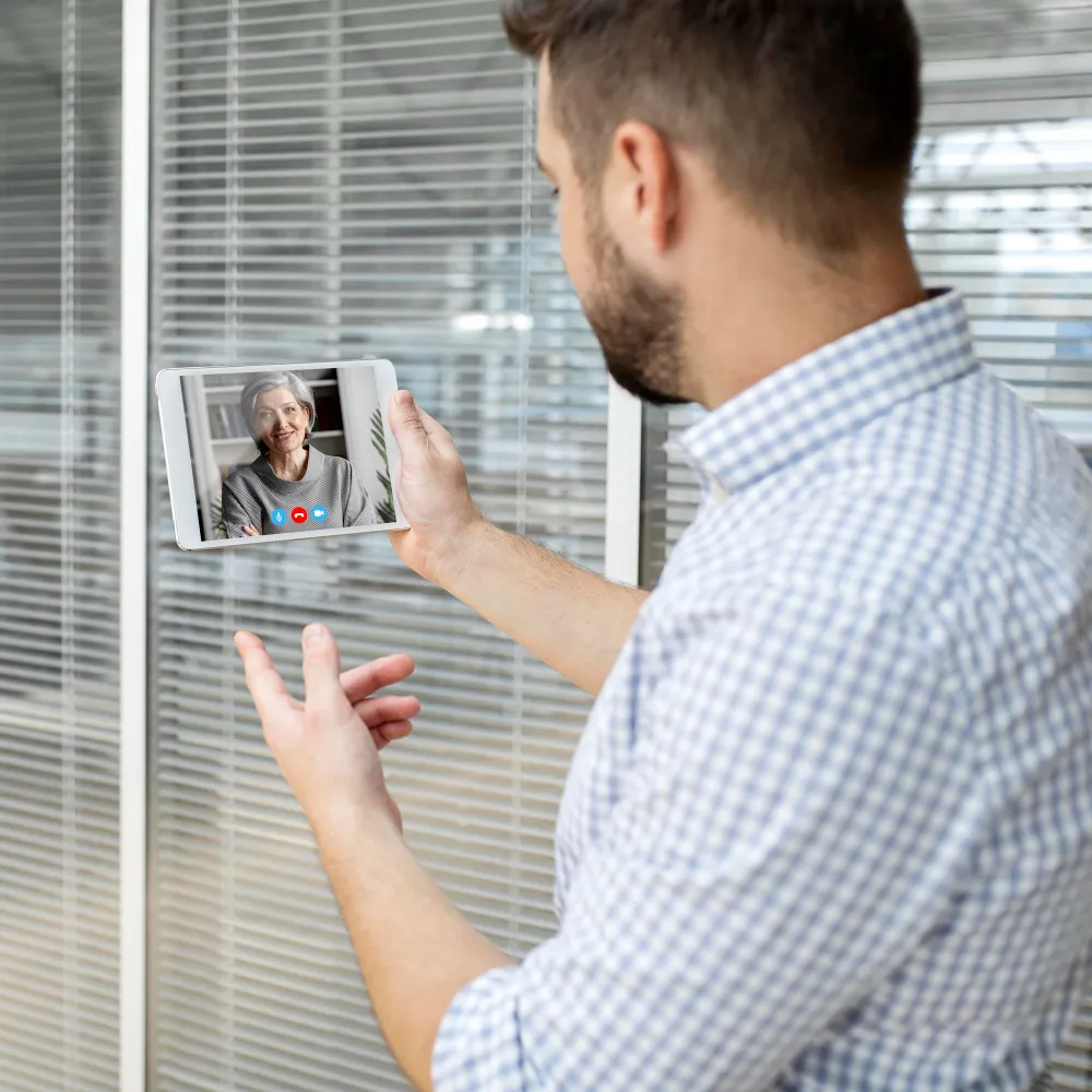 Patient using a tablet for a remote health monitoring solution to communicate with a healthcare provider during a virtual follow-up appointment.