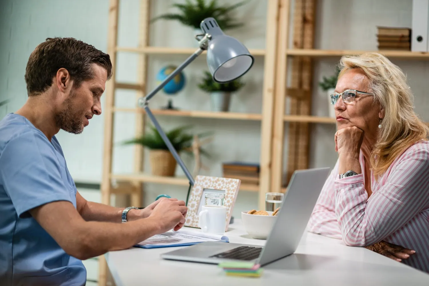 Healthcare professional discussing care plans with an older patient, illustrating Transition Care Management Services and coordinated patient support.