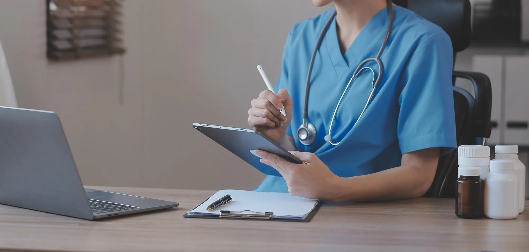 Healthcare provider reviewing patient data on a tablet as part of remote patient monitoring telehealth services.